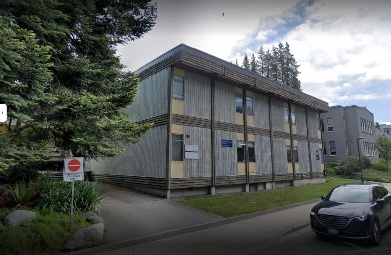 A building within UBC campus with a car passing by.