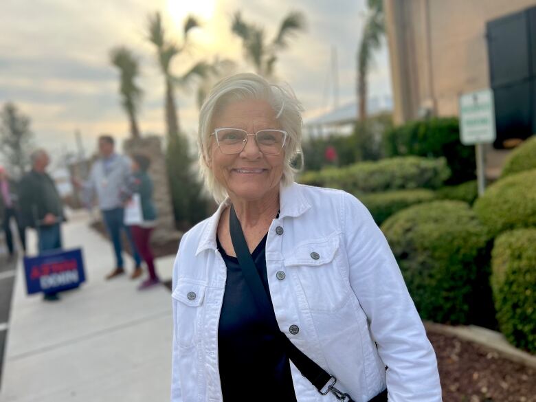 Retiree smiling with palm trees and sunset in the background