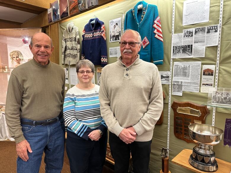 Sam Calles, Marie Stang of the Kimberley Heritage Museum,and Kimberley Curling Club past president John McGillivray.