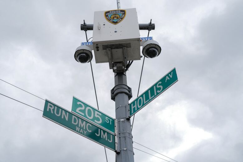 A street sign is photographed from below. The signs bear the words 