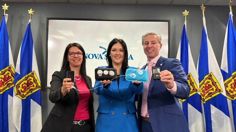 Three people holding diabetes equipment.