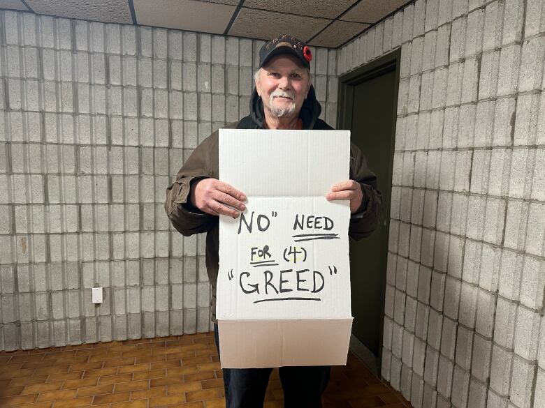 A tenant at 1280 Webster Street holds a sign pushing back on bad faith renovictions. 