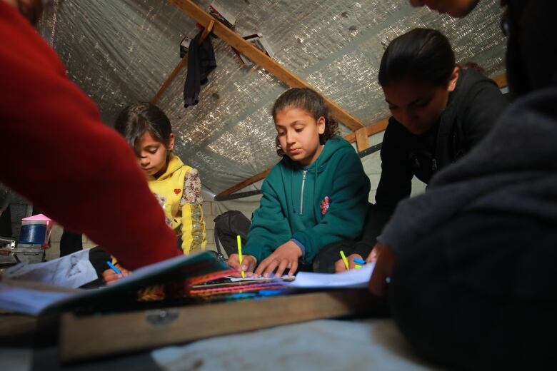 Twelve year old Alma Al Jarrour colours with her cousins in a temporary shelter in Gaza.  She was the sole survivor of an Israeli attack on a mosque on February 2nd,  that also destroyed the home where she and her extended family were staying. 