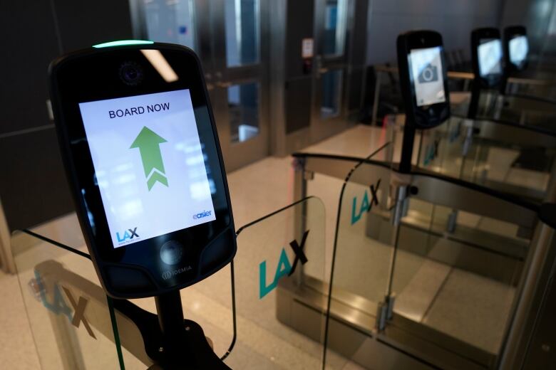 Close up photo of a smart airport gate. A screen displays a green arrow, with the words 