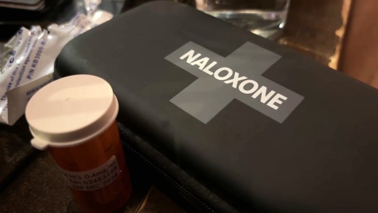 A black case with a cross on the front and the word 'naloxone' printed across.