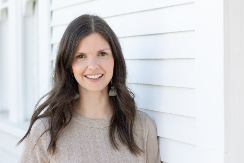 A woman with brown hair outside a house.