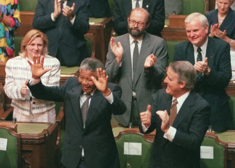 Nelson Mandela raises his arms as he is acknowledged by Prime Minister Brian Mulroney and other members of Parliament in Ottawa, June 18, 1990. Former prime minister Brian Mulroney is dead at 84. His family announced late Thursday that the former Tory leader died peacefully, surrounded by loved ones. 