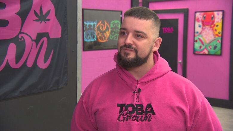 A man in a pink hoodie that says 'TobaGrown'