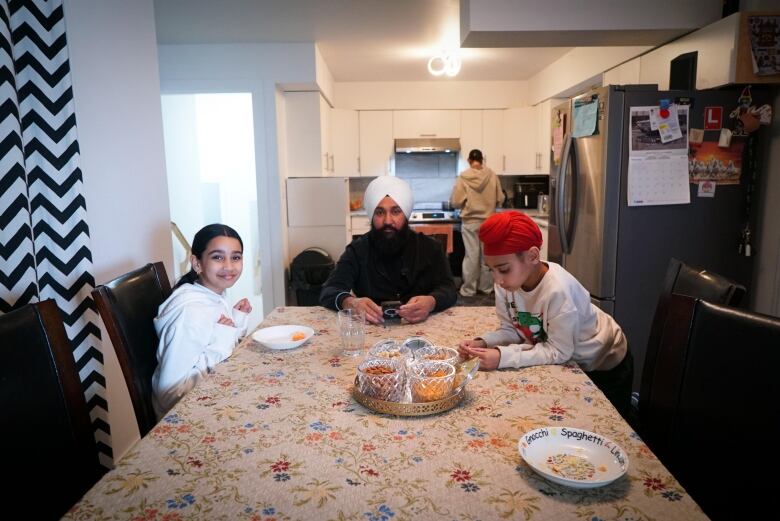 A father and two kids at the kitchen table.