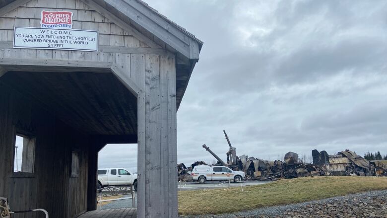 A replica covered bridge stands in front of the burned rubble left after a fire at Covered Bridge Potato Chips's manufacturing plant.