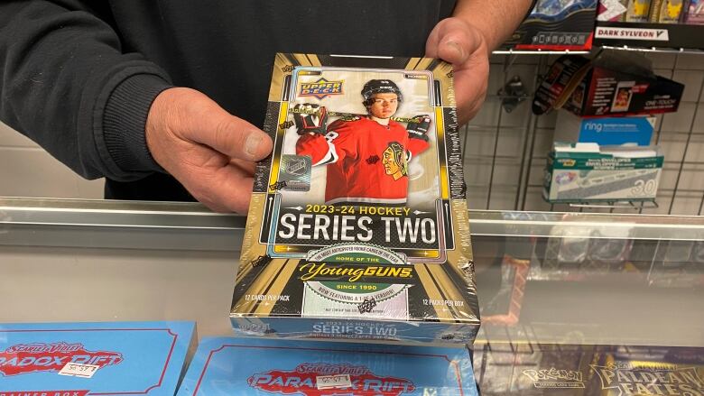 a person is holding a box of hockey cards for the camera