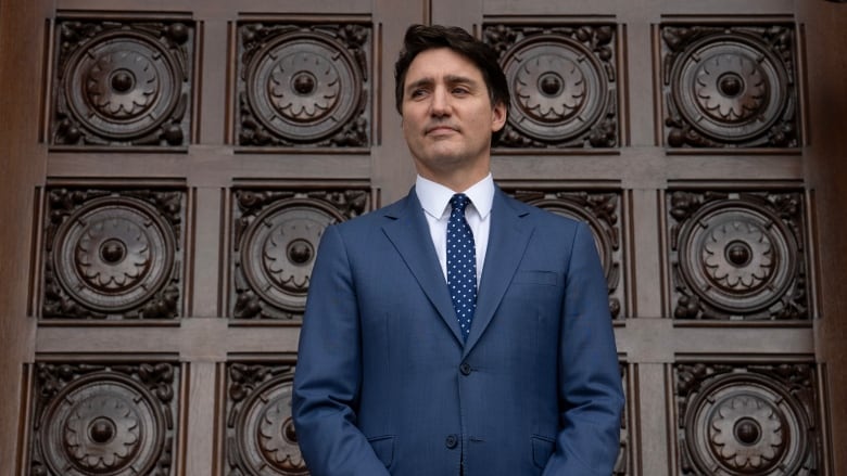 Prime Minister Justin Trudeau waits outside the west doors of West Block in Ottawa.