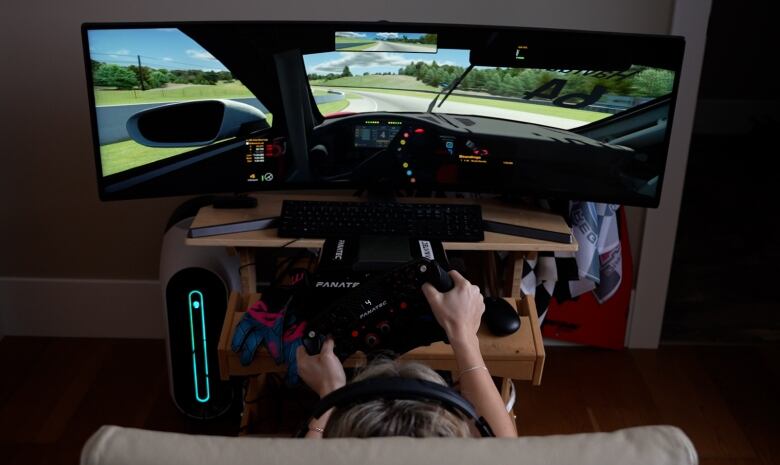 Nicole Havrda sits in front of her racing simulator, and practices driving while at home in Comox. 