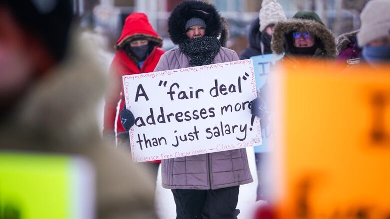 A person holds a sign while walking at a demonstration site 