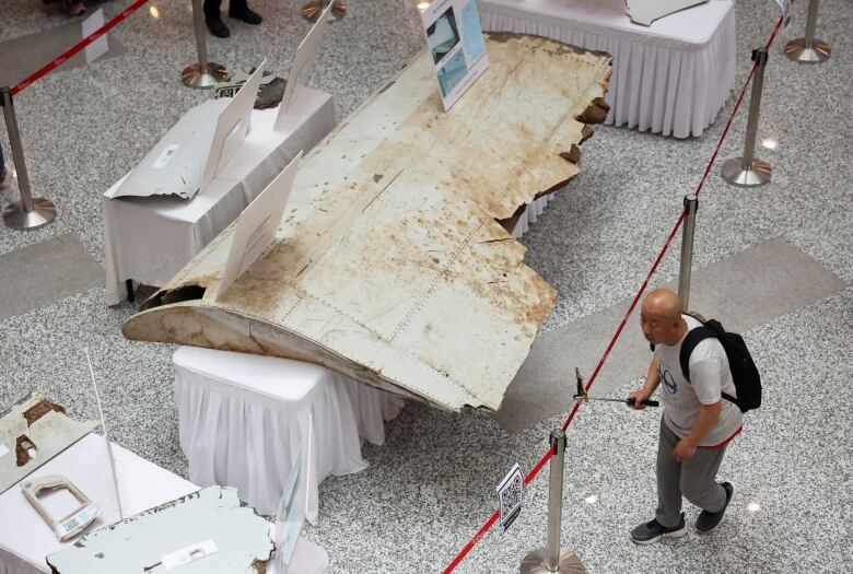 A visitor looks at the wreckage of an aircraft believed to be from the missing Malaysia Airlines flight MH370 during a remembrance event marking the 10th anniversary of its disappearance, in Subang Jaya, Malaysia March 3, 2024.