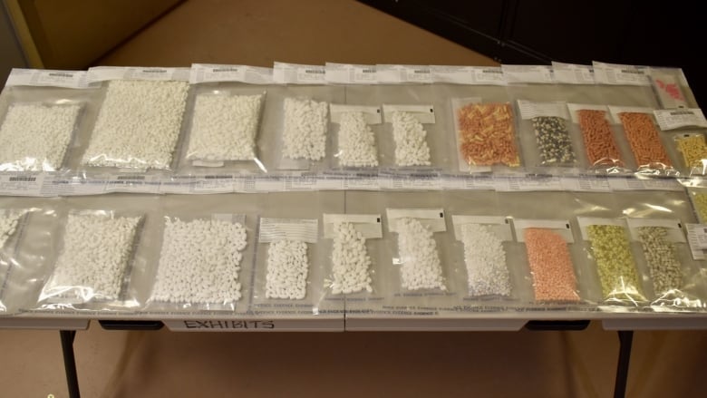 A table with many evidence bags filled with many different pills