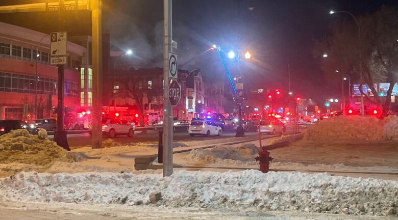 Traffic is lined up on a road as firefighters spray water on a buliding.