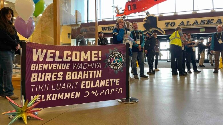 Young people in airport with welcomes sign