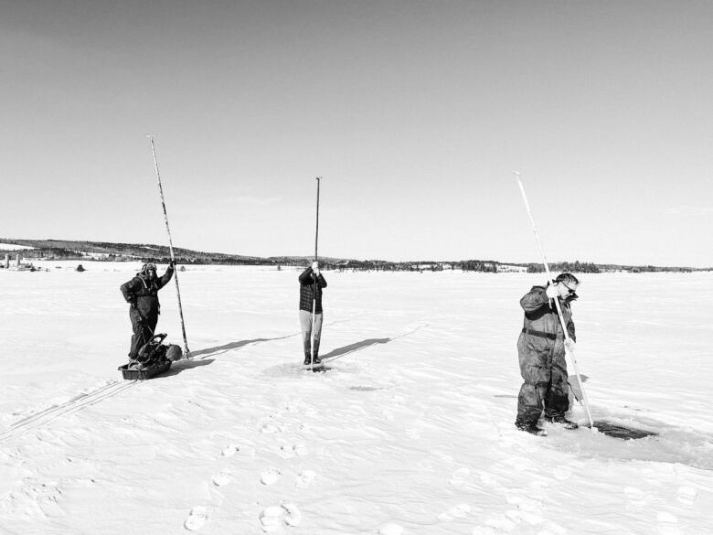 three men out on the ice fishing 