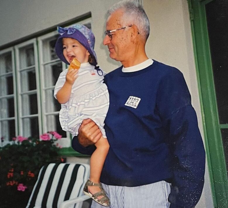 A man holds a young girl in his arm.