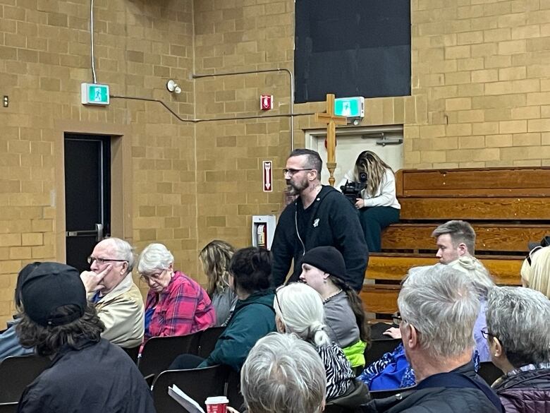 Man speaking at a public meeting about a new emergency complex needs shelter in Regina.