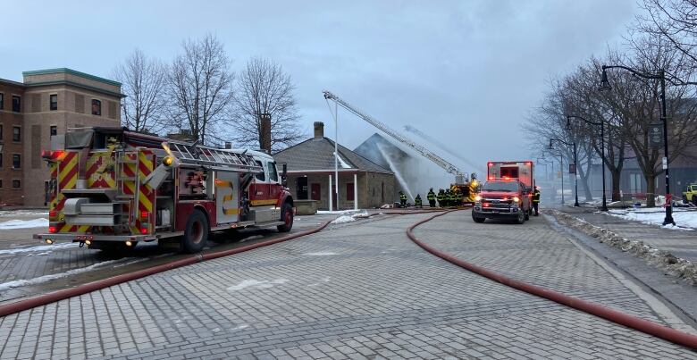 Firefighters spray water on a building in Fredericton.