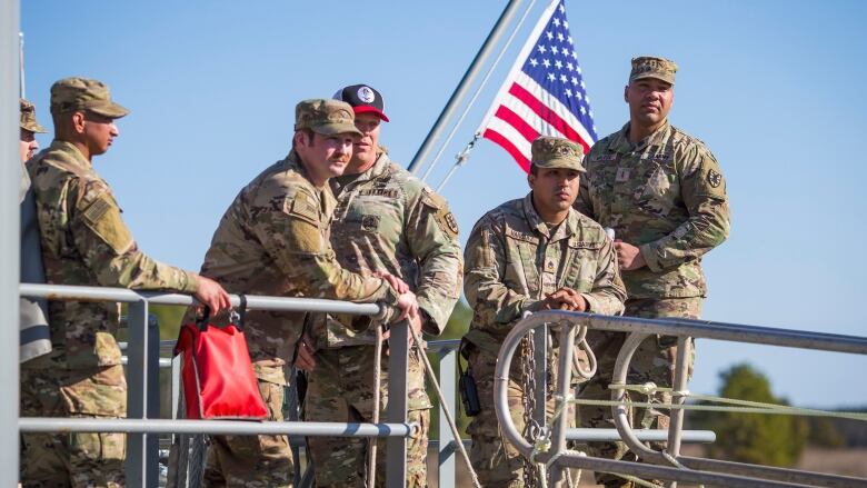 U.S soldiers stand on a military ship.