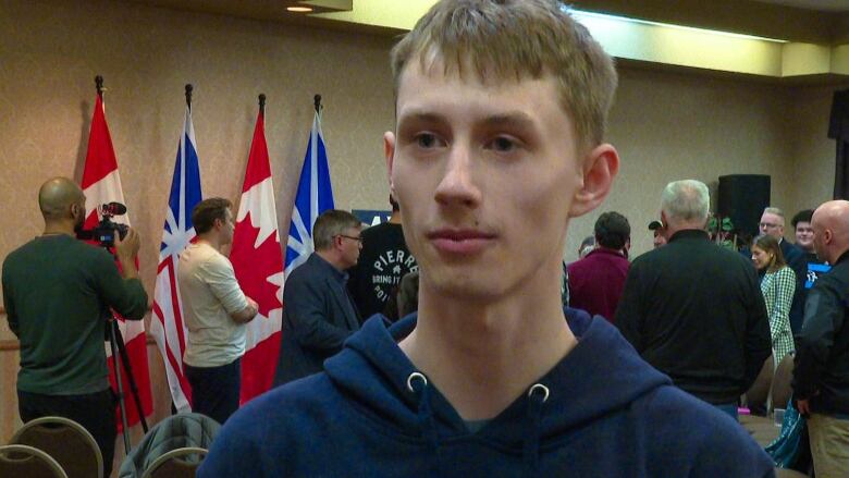 A young boy with a navy blue hoodie looks to the left of the camera.