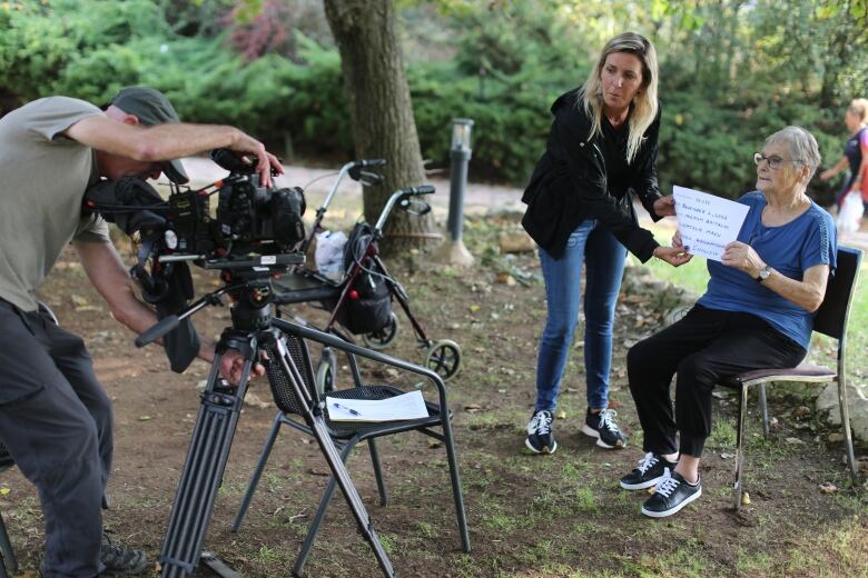 Natalie Mann helps an interviewee get set up for an interview about  her experience of the Oct. 7 Hamas-led attack on Israel.