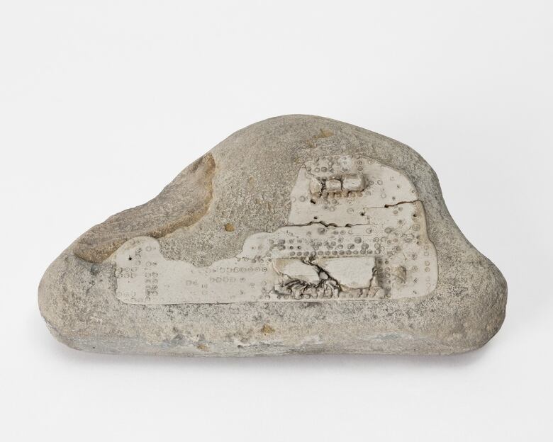 A rock with a fossil of a computer chip in it.