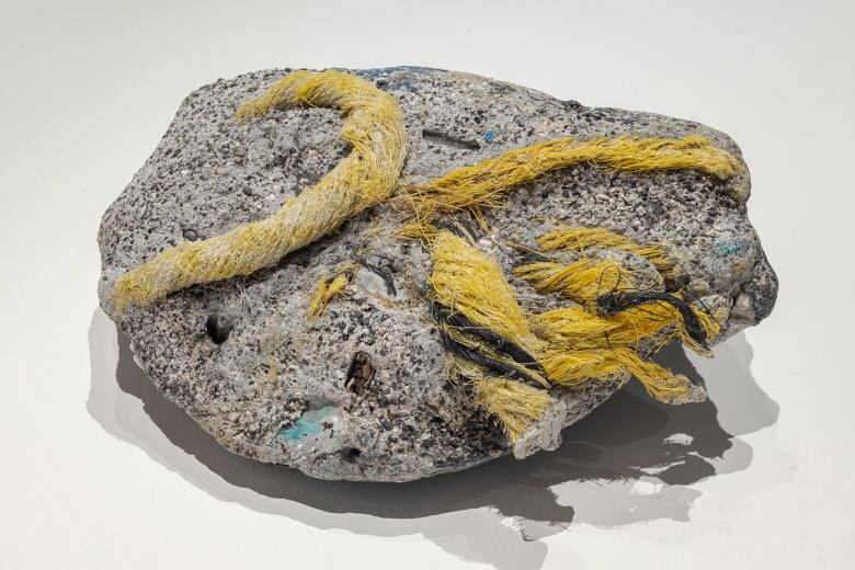 A rock with a yellow rope around it.