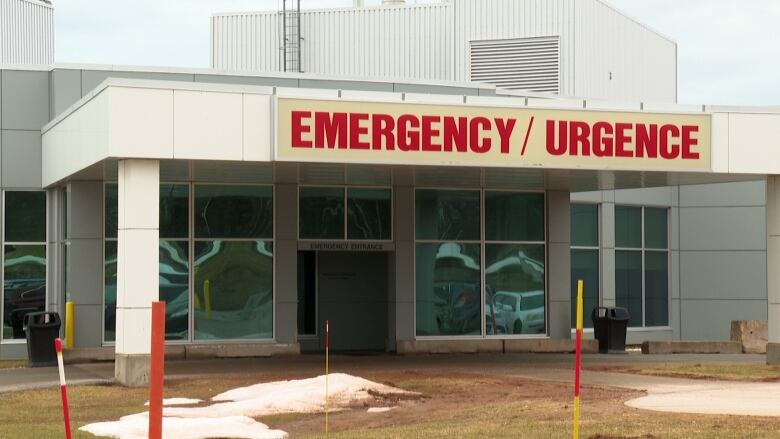 The exterior of a hospital emergency room, with small piles of snow on the ground outside. 