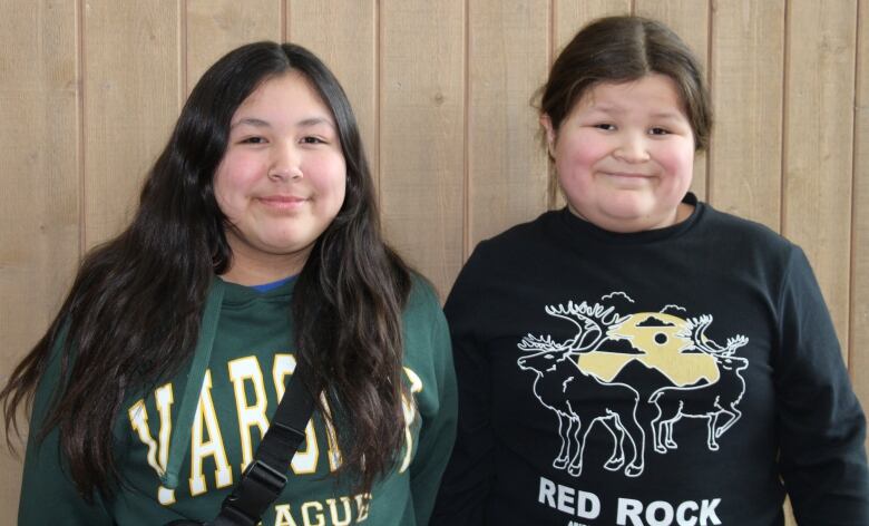 Two Indigenous sibilings smiling at the camera