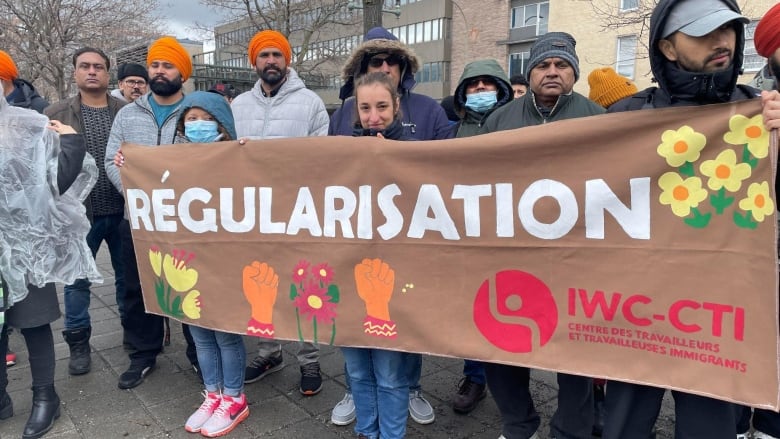 People stand holding a banner.