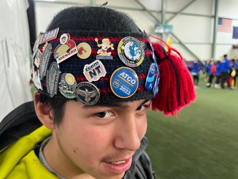 Young man wearing tuque covered in pins