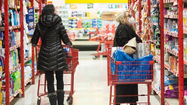 Two women shop in a grocery store.