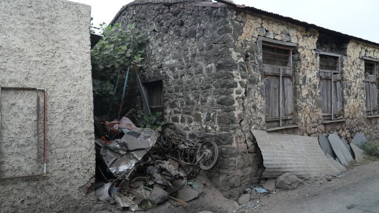 Burnt motorcycles are stacked against the wall of a mosque. 