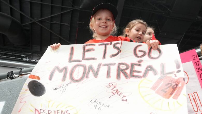 Two young fans hold a sign.