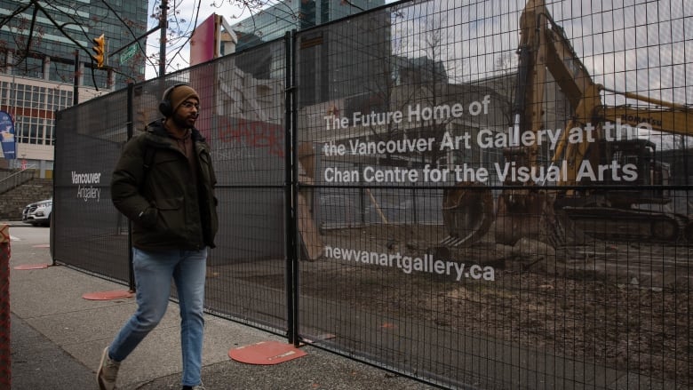 A person walks past a construction site