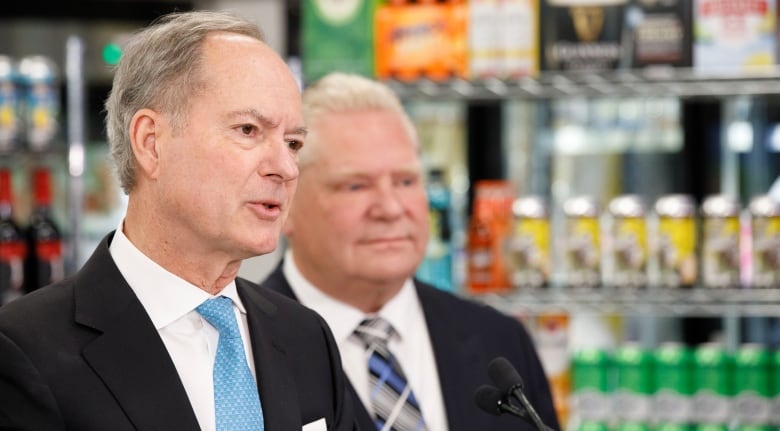 Premier Doug Ford and Finance Minister Peter Bethlenfalvy with displays of beer in the background. 