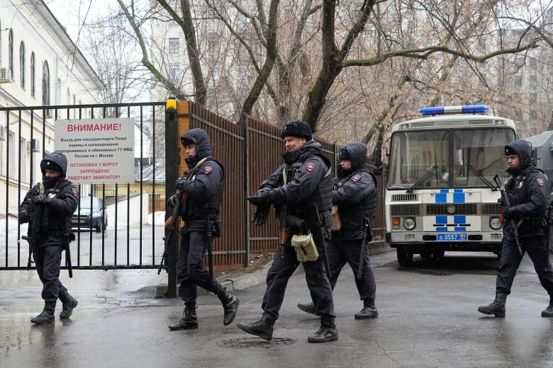 Heavily armed police officers walk outside a court in Moscow. 