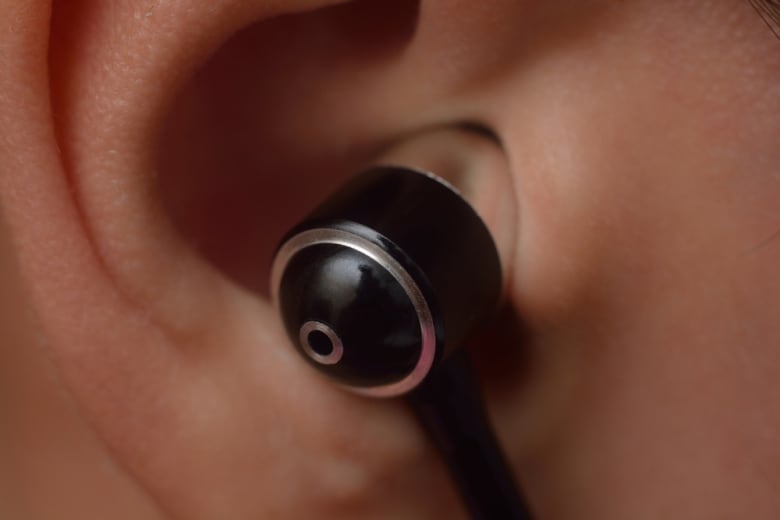 closeup of a black earbud in a person's ear. 