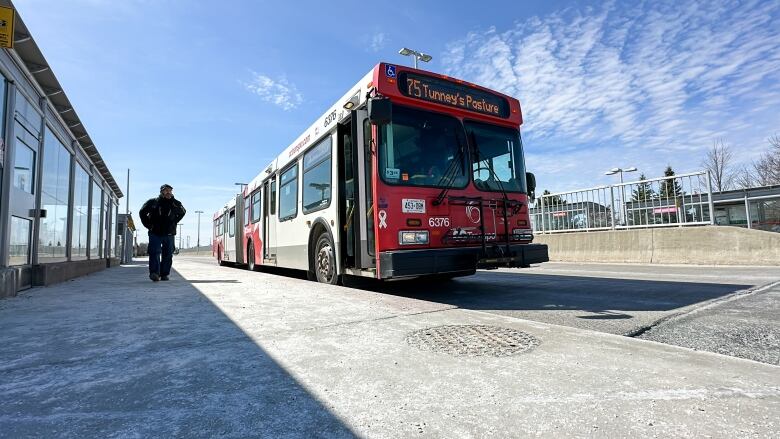 A bus parked at a bus stop in early spring.