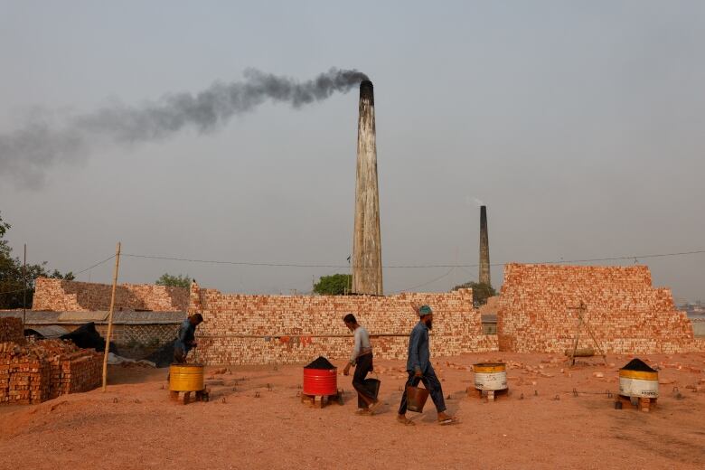 Smoke rises from the chimneys of brick factories on the outskirts of Dhaka, Bangladesh, March 17, 2024. 