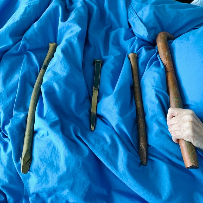 A blue background including what look to be long tubes of copper and brass. 