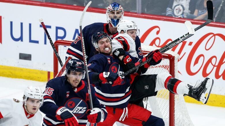 A log jam in front of a hockey net. 