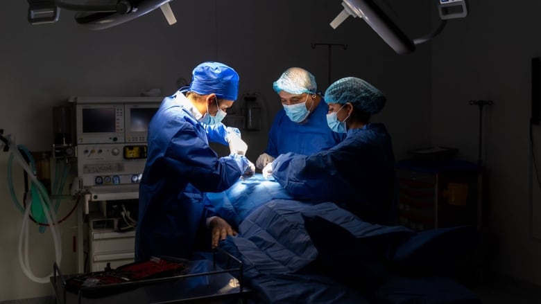 Surgeons perform surgery under bright lights. 