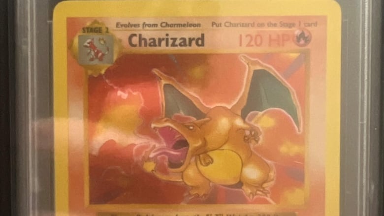 Photo of a Pokemon trading card, 1999 Charizard  Holo Shadowless, in a transparent casing. 