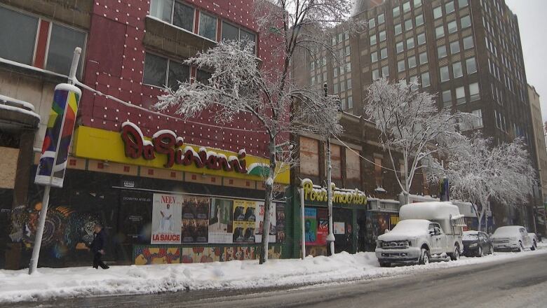 A boarded up building on a snowy day in early April.