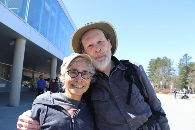 Smiling man and woman with grey hair.